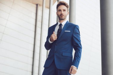 Yakışıklı erkek model mavi bir takım elbise poz.