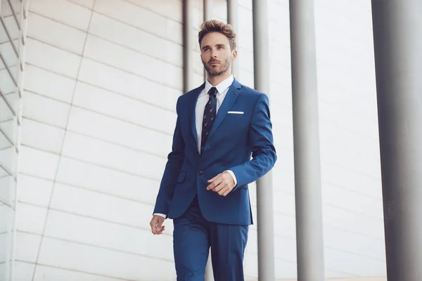 Handsome male model posing wearing a blue suit.