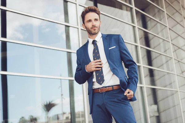 Handsome male model posing wearing a blue suit.