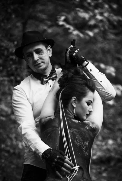 Young man imitating music play on painted viola on woman's back