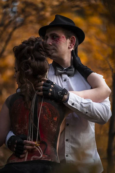 Un uomo che abbraccia una donna con il violoncello disegnato sulla schiena — Foto Stock