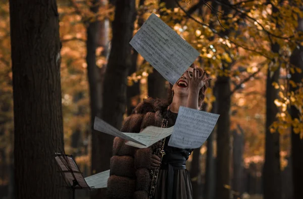 Müzik sayfaları atma abanoz tutan genç çekici kadın — Stok fotoğraf