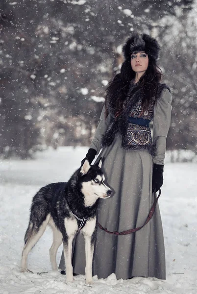 Állandó a husky a hó park a gyönyörű fiatal nő portréja — Stock Fotó