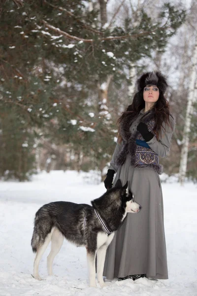 Retrato de mulher bonita de pé com lobo no parque de neve — Fotografia de Stock