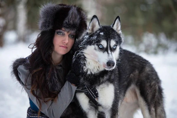 Портрет молодой женщины с собакой на фоне зимнего парка — стоковое фото