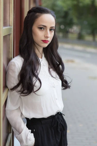 Jonge brunette vrouw gekleed in witte blouse op straat — Stockfoto