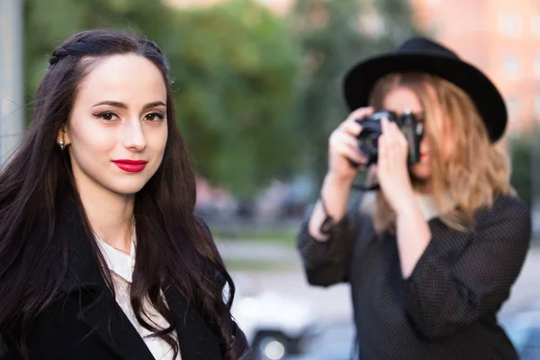 One girl photoshooting another girl outdoors — Stock Photo, Image