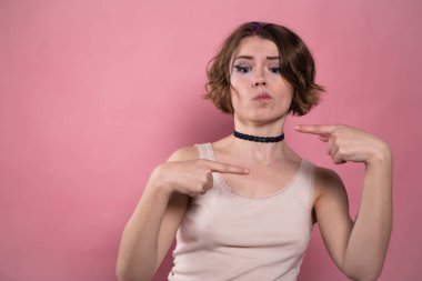 Gömlek ve işaret parmağı yukarıyı gerdanlık genç kadın portresi.