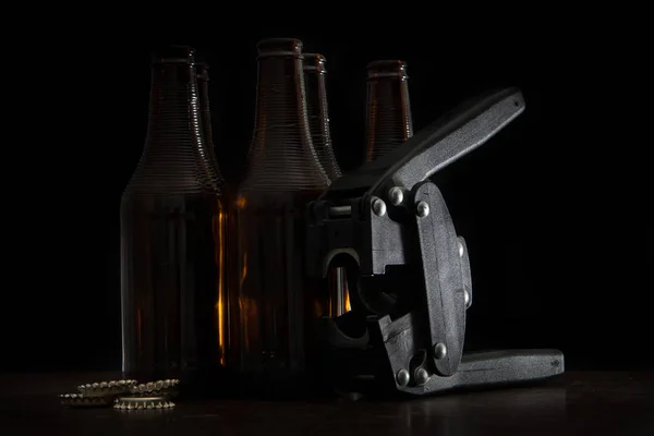 Hand capper with five dark brown bottles and caps — Stock Photo, Image