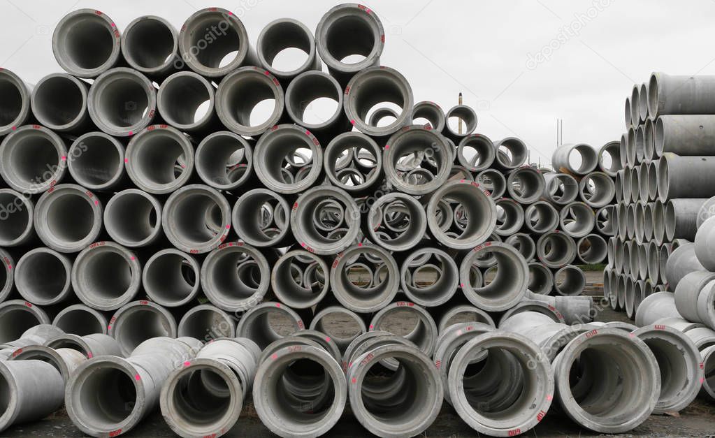 Concrete round pipes stacked in heap. 