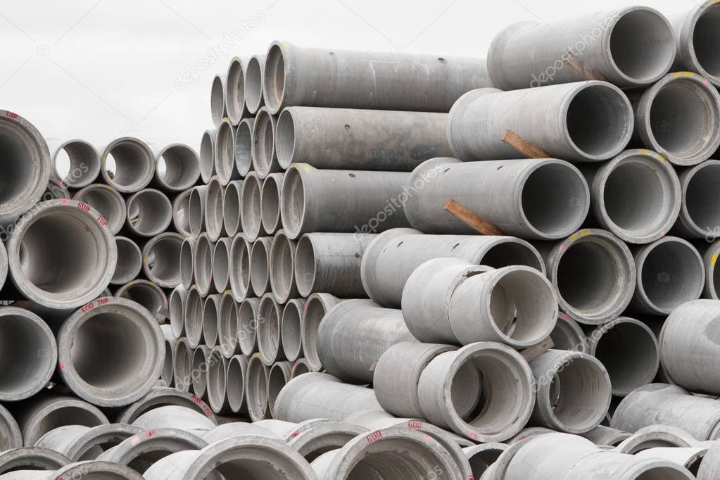 Concrete round pipes stacked in heap