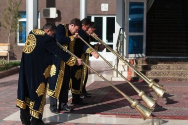 Taşkent, Özbekistan - 9 Aralık 2011: Müzisyen erkeklerde karnay oynayan geleneksel kaftanlar