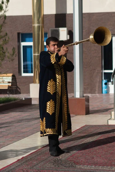 Taschkent Usbekistan - 9. Dezember 2011: Musikermänner in traditionellen Kaftans, die Karnay spielen — Stockfoto