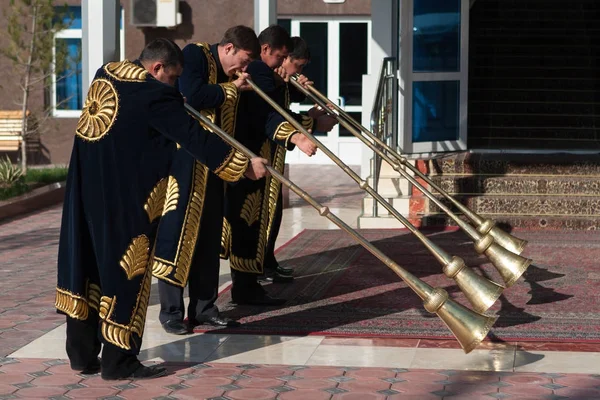 Taschkent Usbekistan - 9. Dezember 2011: Musikermänner in traditionellen Kaftans, die Karnay spielen — Stockfoto