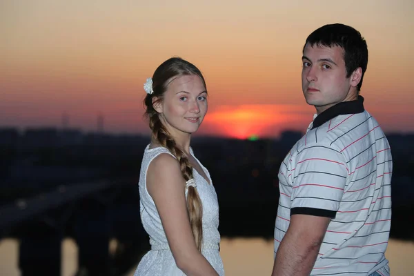 Lyckliga Unga Paret Ser Tillbaka Den Vackra Solnedgången Bakgrunden — Stockfoto