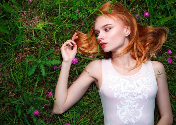 Jovem mulher bonita deitada na grama — Fotografia de Stock