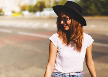 Gülümseyen kız hipster şapka wlaking sokak tarafından
