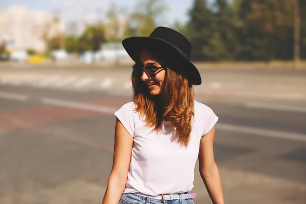 Smiling girl hipster in hat wlaking by the street — Stock Photo, Image