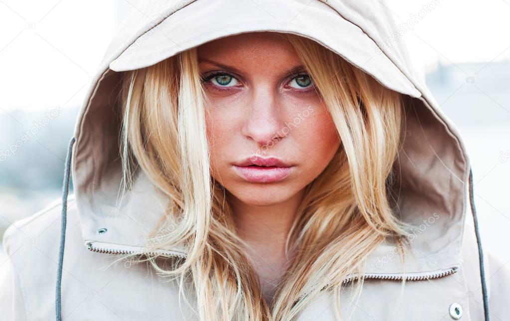 Outdoor portrait of young sensual woman in the hood closeup