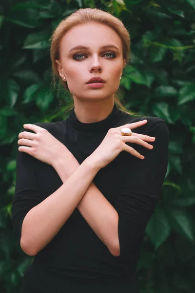 Jovem bonito mulher contra fundo de verão verde parque verde folhas olhando para a câmera — Fotografia de Stock