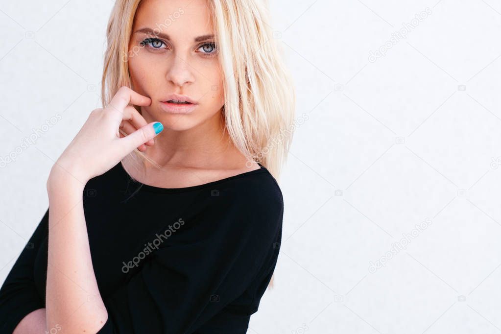 Beautiful young blonde girl on white close-up portrait.