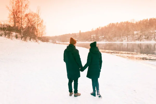 Couple Holding Hands Walking Away. Winter, Sunny, Forrest, Recreation, Leisure, Clothing.