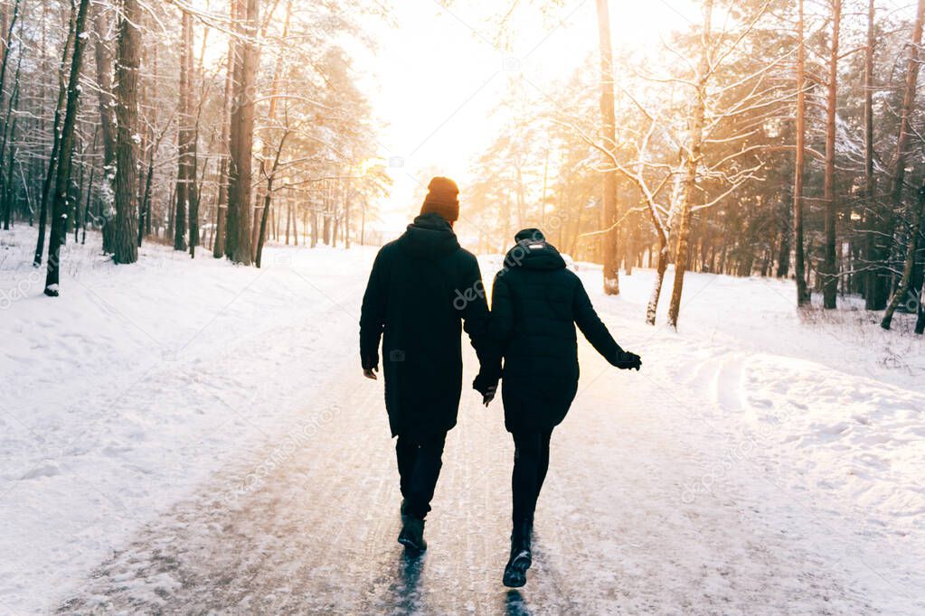 Couple Holding Hands Walking Away. Winter, Sunny, Forrest, Recreation, Leisure, Clothing.