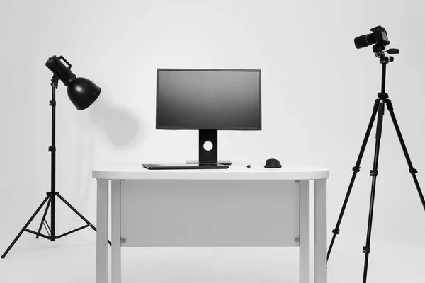 Photographer working place in photo studio with lighting equipment. Camera on the tripod. PC computer on desk. Designer working place. — Stock Photo, Image