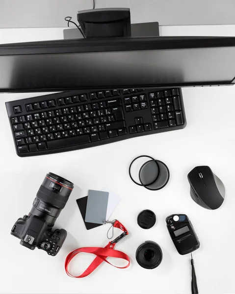 Blick von oben auf den Arbeitsplatz des Fotografen. Ansicht von der Arbeitsplatte. Fotokamera mit großem Makroobjektiv und Fotoausrüstung. flache Lagesicht — Stockfoto