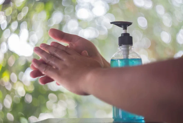 Arka planda alkol jeli temizleme eli.