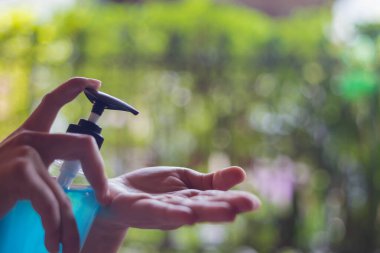 Arka planda alkol jeli temizleme eli.