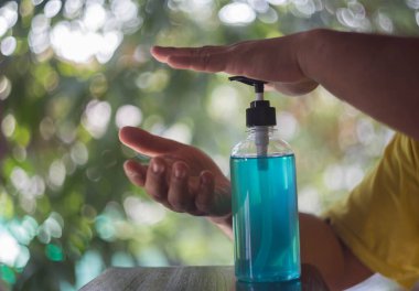 Arka planda alkol jeli temizleme eli.