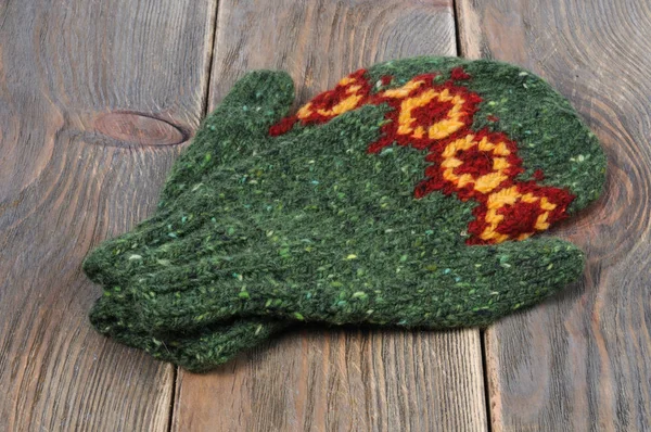 Ahşap bir zemin üzerine yeşil el yapımı eldiven. Önden Görünüm.
