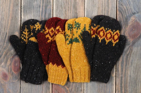 Four mittens. Wooden background. View from above. — Stock Photo, Image