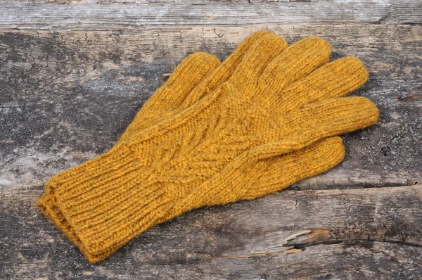 木製の背景に黄色の手作り手袋 フロント ビュー — ストック写真