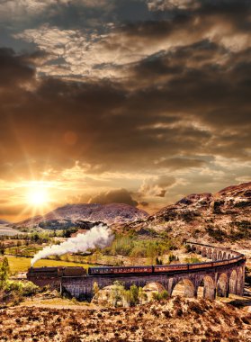 Glenfinnan demiryolu Viyadüğü üzerinde göl günbatımı karşı Jacobite buharlı tren ile İskoçya'da