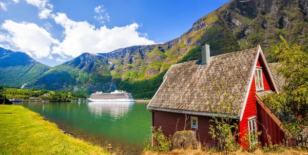 Červené Chata proti výletní lodi ve fjordu, Flam, Norsko — Stock fotografie