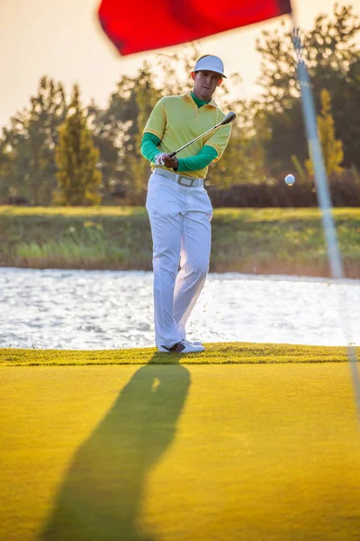 Homem jogando golfe contra o pôr do sol colorido — Fotografia de Stock
