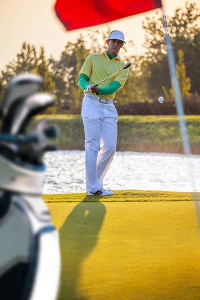 Hombre jugando golf contra colorido atardecer — Foto de Stock
