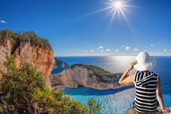 Mujer con sombrero mirando la playa de Navagio con naufragio en la isla de Zakynthos en Grecia — Foto de Stock