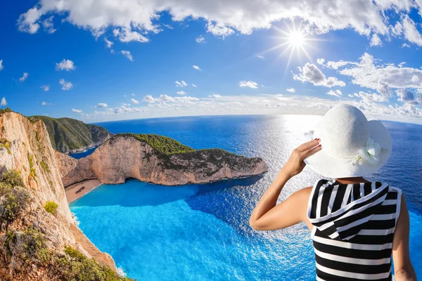 Mulher com chapéu assistindo Navagio praia com naufrágio na ilha de Zakynthos, na Grécia — Fotografia de Stock