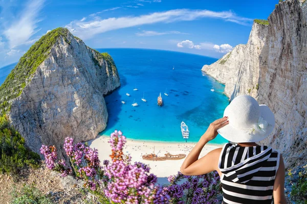 Mulher com chapéu assistindo Navagio praia com naufrágio na ilha de Zakynthos, na Grécia — Fotografia de Stock