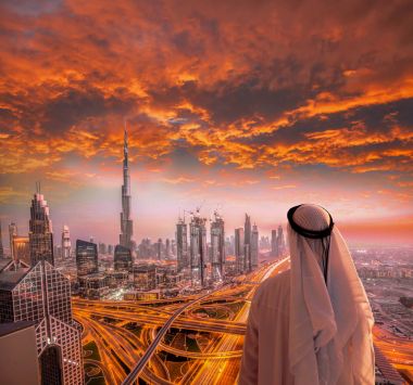 Arabian man watching cityscape of Dubai with modern futuristic architecture in United Arab Emirates. clipart