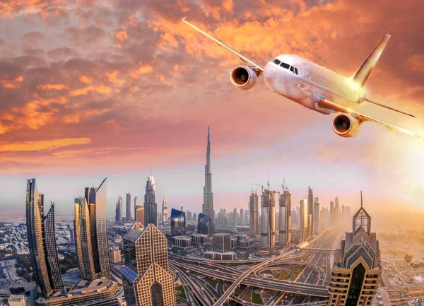 Flugzeug fliegt über Dubai gegen den farbenfrohen Sonnenuntergang in den Vereinigten Arabischen Emiraten — Stockfoto