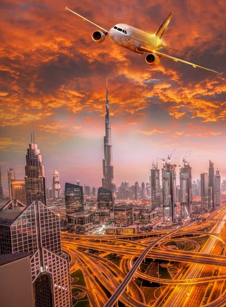 Letadlo letí nad Dubaj proti barevný západ slunce v Spojených arabských emirátech — Stock fotografie