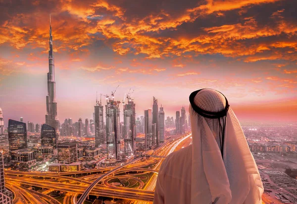 Arabský muž, který sledoval panoráma Dubaje s moderní futuristické architektury ve Spojených arabských emirátech. — Stock fotografie