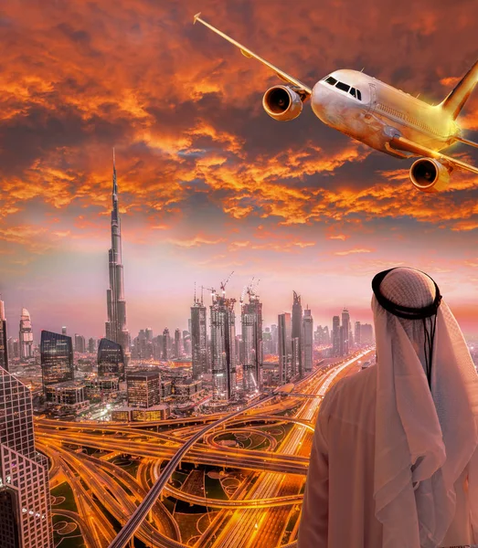 Arabian man med flygplan som flyger över Dubai mot färgsprakande solnedgång i Förenade Arabemiraten — Stockfoto