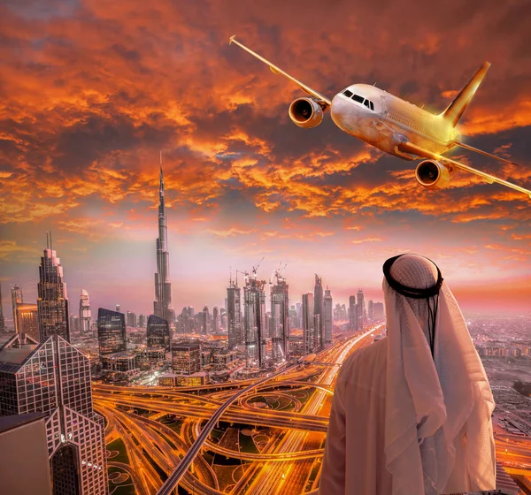 Arabian man med flygplan som flyger över Dubai mot färgsprakande solnedgång i Förenade Arabemiraten — Stockfoto