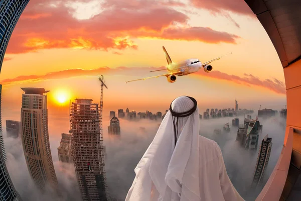 Arab ember néz repülőgép repülő felett Dubai, Egyesült Arab Emírségek — Stock Fotó