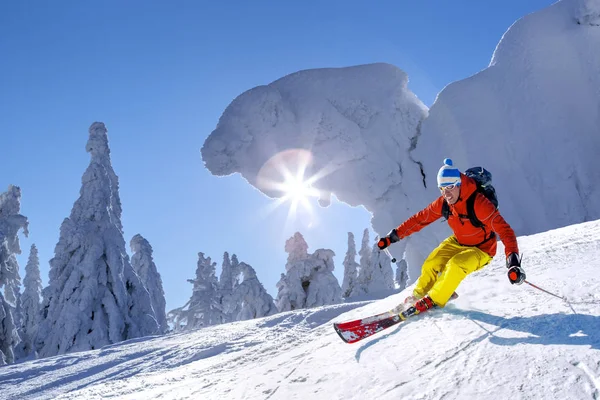 Skifahrer fährt im Hochgebirge vor blauem Himmel abwärts — Stockfoto